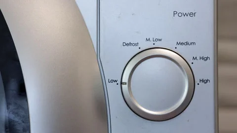 A Man's Hand Sets The Microwave Oven. The Hand Turns The Knob From Low To High.  Video stock 249663692
