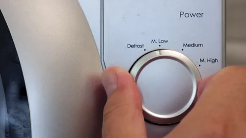 A Man's Hand Sets The Microwave Oven. The Hand Turns The Knob From Low To M.High Stock Footage 249995380