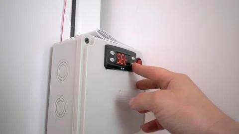 A man's hand sets the temperature on the refrigerator control module. Stock Footage 176939052