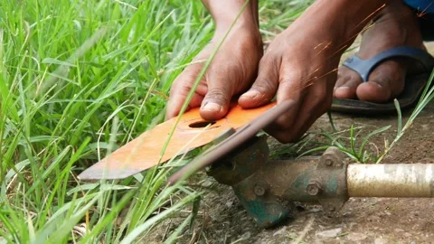 Man's hand sharpening lawn mower blade using sandpaper grinder Stock Footage 306779088