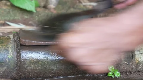 A mans hand sharpening a machete on a sharpening stone Stock Footage 312095574