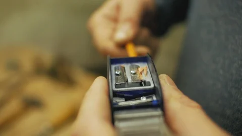 Man's hand is sharpening a pencil on a sharpener Stock Footage 102056669