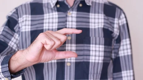 Man's hand showing something small in size 動画素材 94137815