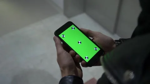 Man's hand shows mobile smartphone with green screen Stock Footage 210757448