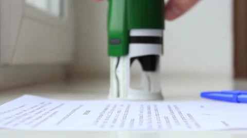 Man's hand signs a document and puts a stamp close-up Stock Footage 224722423