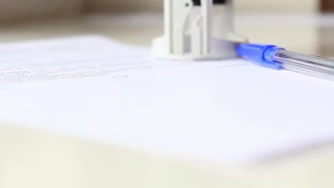 A man's hand signs a document with a pen and puts a stamp, seal Stock Footage 227749271