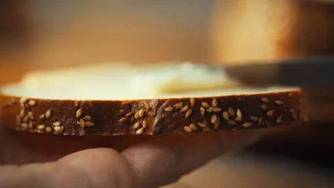 A mans hand skillfully spreads a layer of creamy cheese on a surface using a Vidéo 331452952