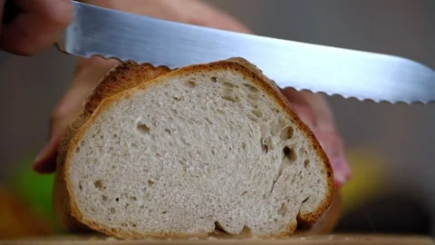 Man’s Hand Slicing Crispy Homemade Bread. Handmade traditional bakery breakfast. Stock Footage 300311341