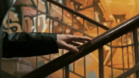 Man's hand slides to hold onto the railing in the stairwell of a building Stock Footage 287914931