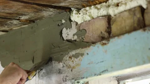 A man's hand with a spatula spreads putty on the wall Stockbeeldmateriaal 221473801