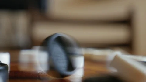 Man's hand spinning a checker in the table, close up Video stock 104933189