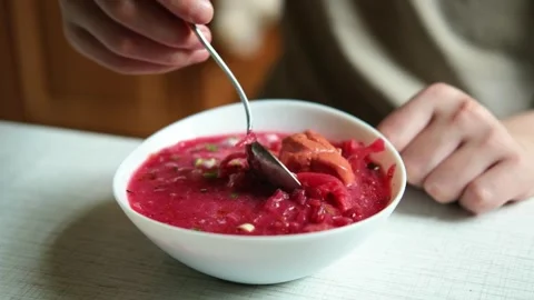 A man's hand with a spoon, a man eating his borscht sitting at a table.  Stock Footage 282960597