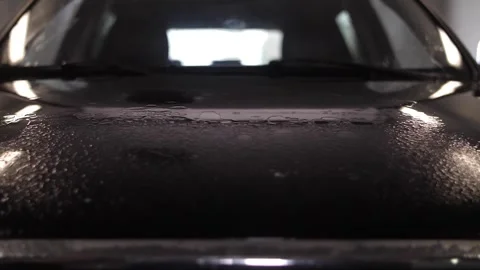 Man's hand spraying detergent on car to clean in car washing service. Stock Footage 262546141