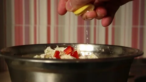 A man's hand squeezes lemon into a salad Stock Footage 324766649