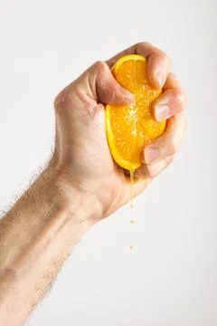 Man's Hand Squeezing Orange Half Stock Photos
