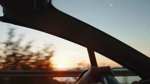Man's hand on steering wheel, driving a car at sunset. road trip at sunset. Stock-Footage 336266293