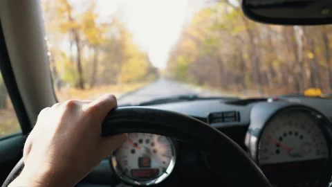 A man's hand is on the steering wheel while driving a car on a autumn day. First Stock Footage 141468926