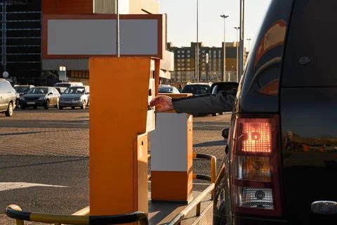 Man's hand take ticket in control tickets machine at vehicle entrance with boom Stock Photos
