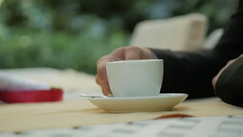 Man's hand takes a cup of coffee from plate on table. Stock Footage 89671128