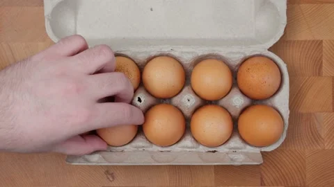 Man's hand takes an egg out of the box Video stock 235512292