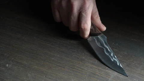 Man's hand takes a forged sharp knife from the wooden table, close up Stock Footage 304002850