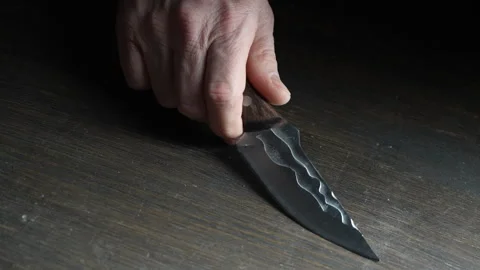 Man's hand takes a forged sharp knife from the wooden table, close up Stock Footage 304785703