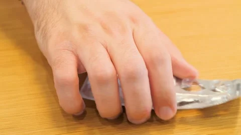 A man's hand takes the opened package of pills from the table. Stock Footage 269834056