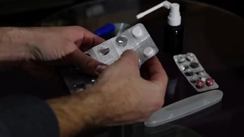 A man's hand takes a pill from a pill board Stock Footage 258796380