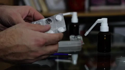 A man's hand takes a pill from a pill board Stock Footage 258796422
