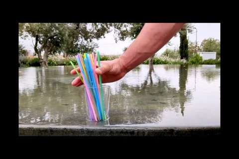 Mans hand takes plastic cocktail tubes from glass and put back bamboo tubes Stock Footage 310083448