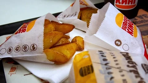 A man's hand takes a slice of potato .Fast food Burger King. Russia Moscow 2022 Stock Footage 222063850
