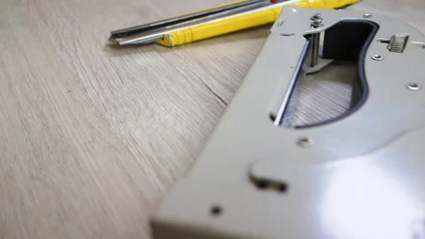 A man's hand takes a stapler from the table. Old tools are on the table. On the Video stock 145423902