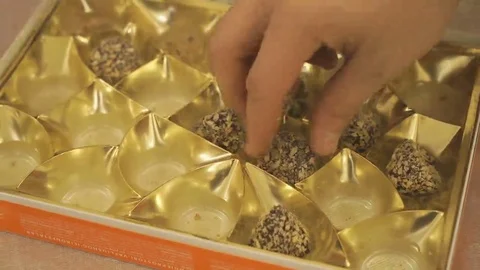 Man's hand taking a chocolate truffle from a box Stock Footage 69257360