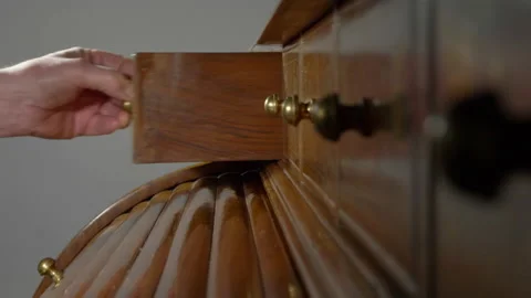 Man's hand taking an item from a small drawer in an ornate wooden desk. Video stock 164917478