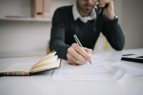 Man's hand taking notes in business documents Foto stock
