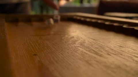 A man's hand throws colorful dice on a wooden backgammon board Stock Footage 161756636