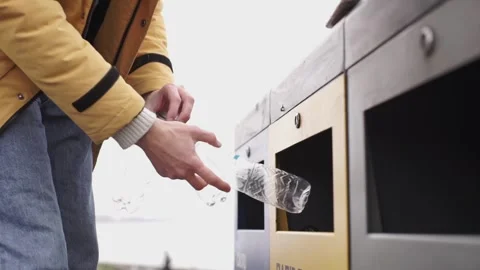 A man's hand throws a container for recycling plastic bottles, garbage sorting Stock Footage 265236554