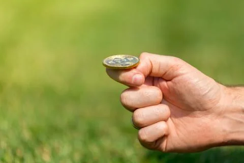 A man's hand throws a gold coin bitcoin Stock Photos