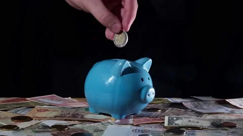Man's hand throws two euros into a blue piggy bank Video stock 233954446
