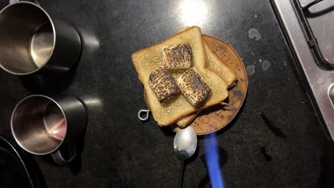 A man's hand toasts white bread with a tourist gas burner Stock-Footage 178898191