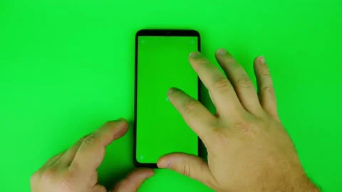 Man's hand touch and scroll of mobile phone with vertical green screen and Stock Footage 131065016
