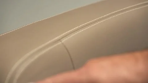 A mans hand touching stitching on leather seat as he describes the product Stock Footage 155539784