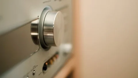 Man's hand turning a dial to increase and decrease volume on hifi stereo 動画素材 94821369