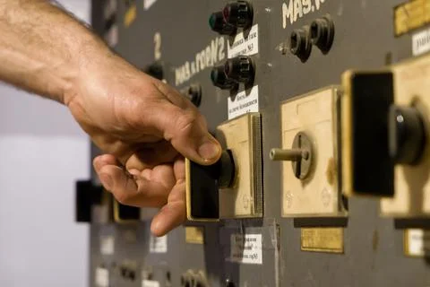 A man's hand turning an old remote control key on a plant Fotos Stock