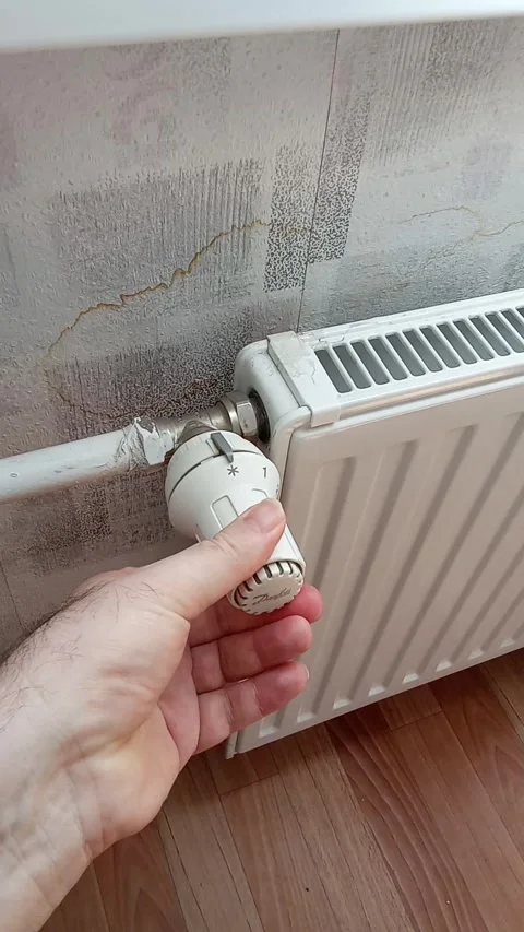 A man's hand turns the battery-powered radiator. Stock Footage 308938596