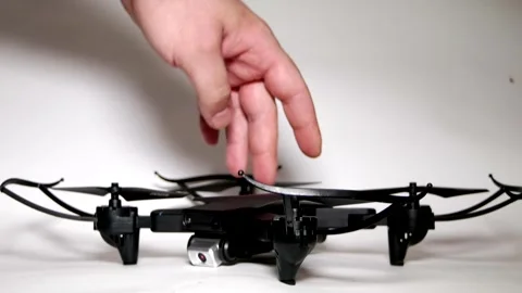 A man's hand turns on a drone and the lights start flashing. Stock Footage 342256925