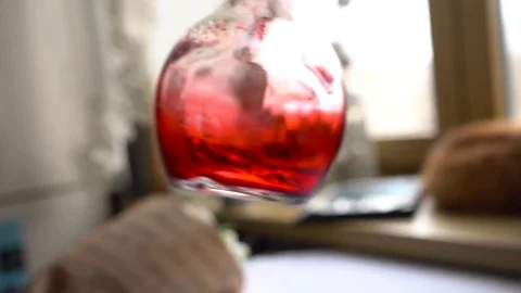 Man's hand turns the flask with red chemical Video stock 73792804