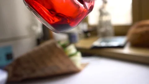 Man's hand turns the flask with red chemical Stock Footage 73792815