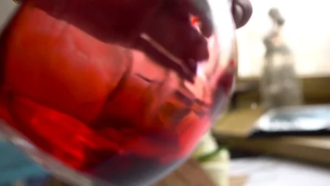 Man's hand turns the flask with red chemical Video stock 73792833