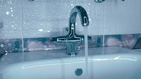 A man's hand turns the handle to turn on the water in a shiny, chrome faucet Stock Footage 297791376